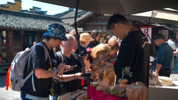 “五一”期間，游客正在烏鎮(zhèn)“水鄉(xiāng)碼頭”挑選購(gòu)買(mǎi)文創(chuàng)產(chǎn)品。受訪者供圖