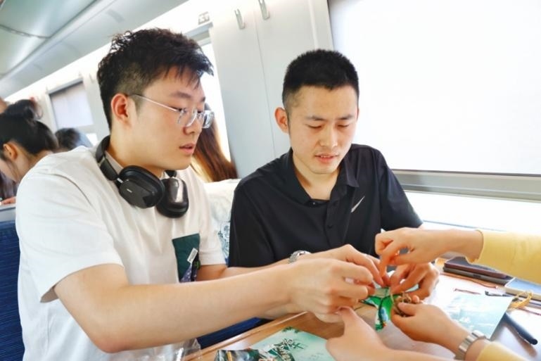 G232次旅客親手制作端午荷包和五彩繩。王磊攝